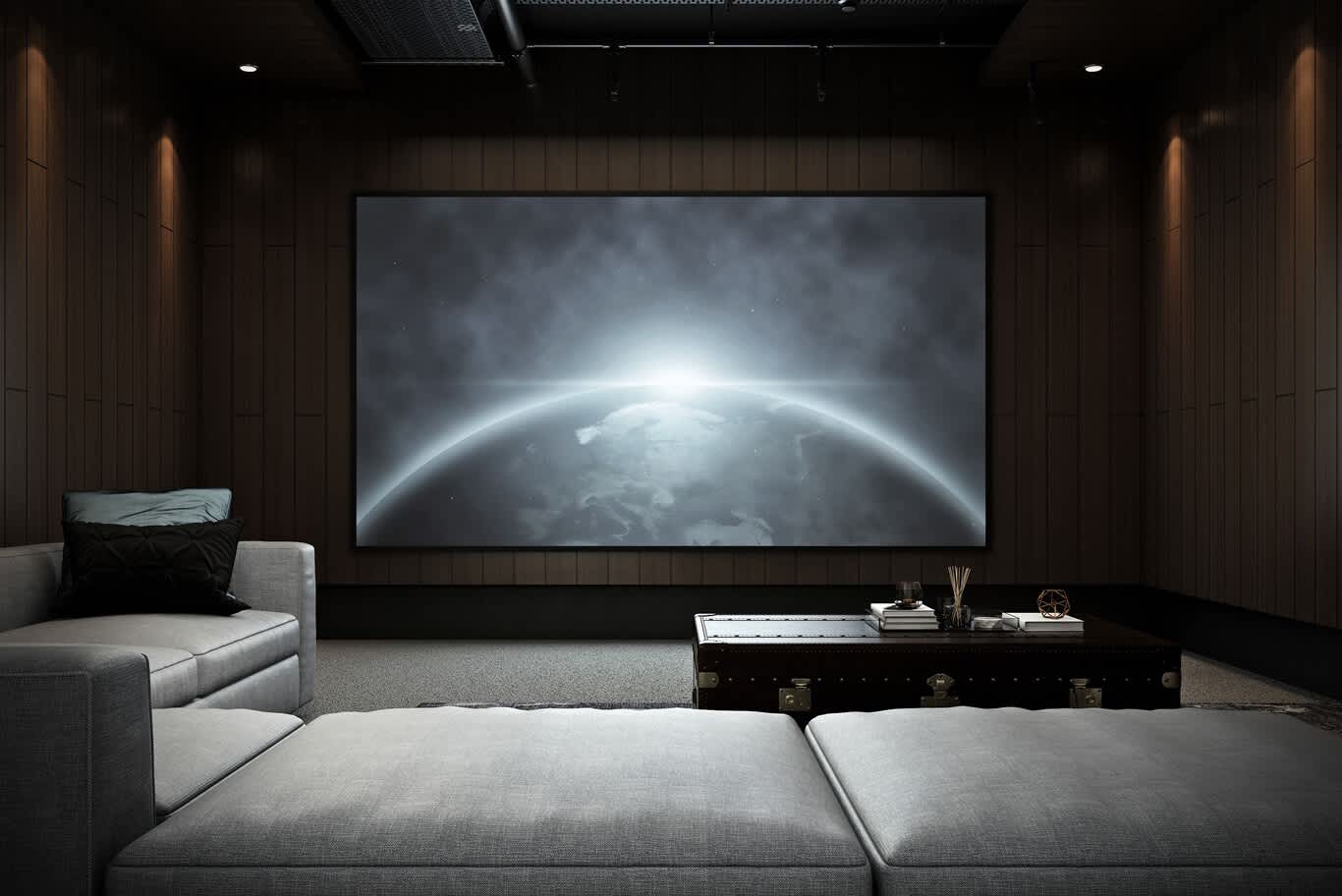 •	Front view of a home cinema screen framed by dark timber battens, seen from a grey lounge sofa