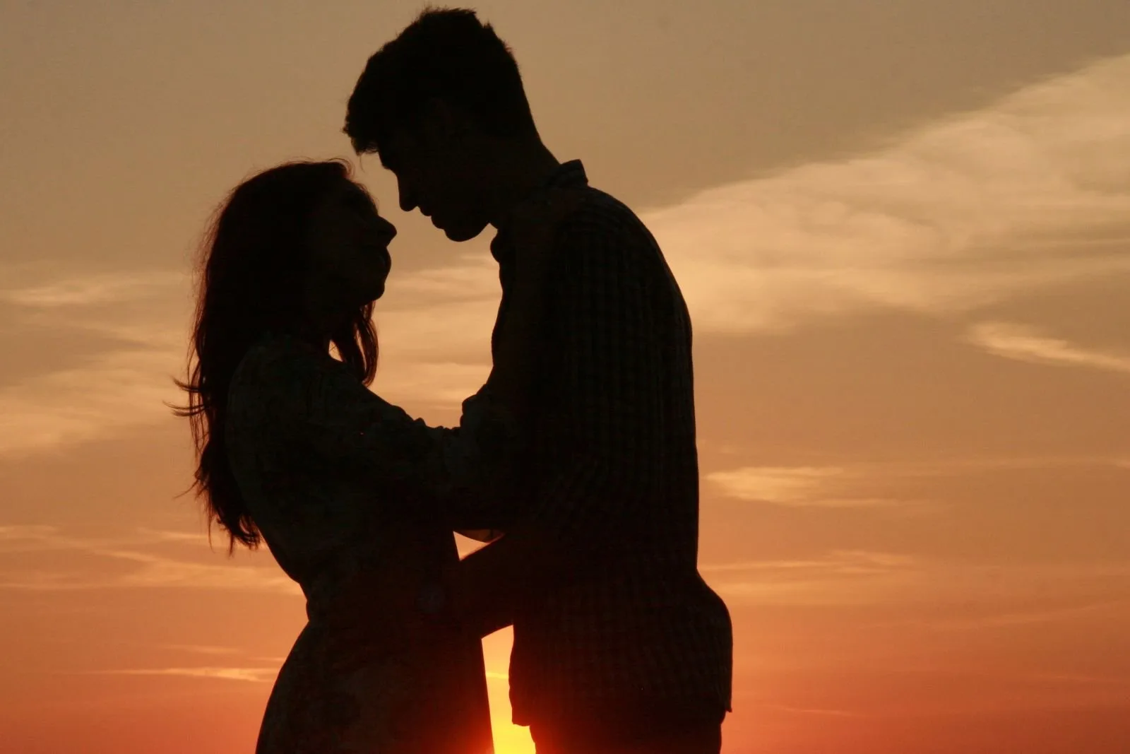 couple kissing at sunset