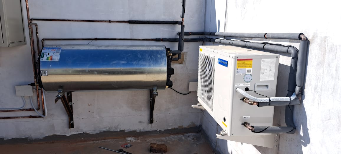 A modern water heater installed in a clean utility room.