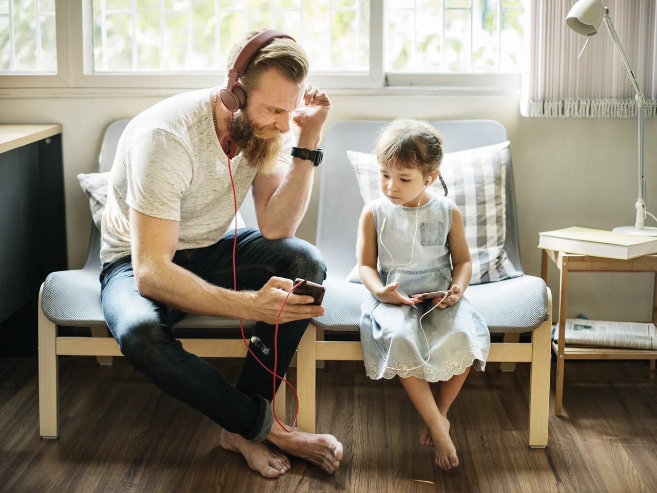 Father and daughter listening to music in apartment rented through rentalassistance loan