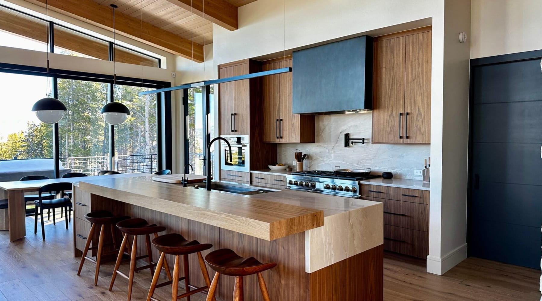 Open kitchen with oak island and dark tall cabinets