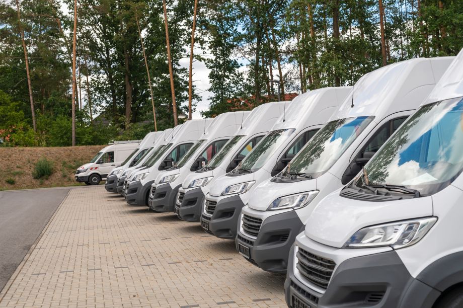 Large white vans for hire parked in a row outdoors