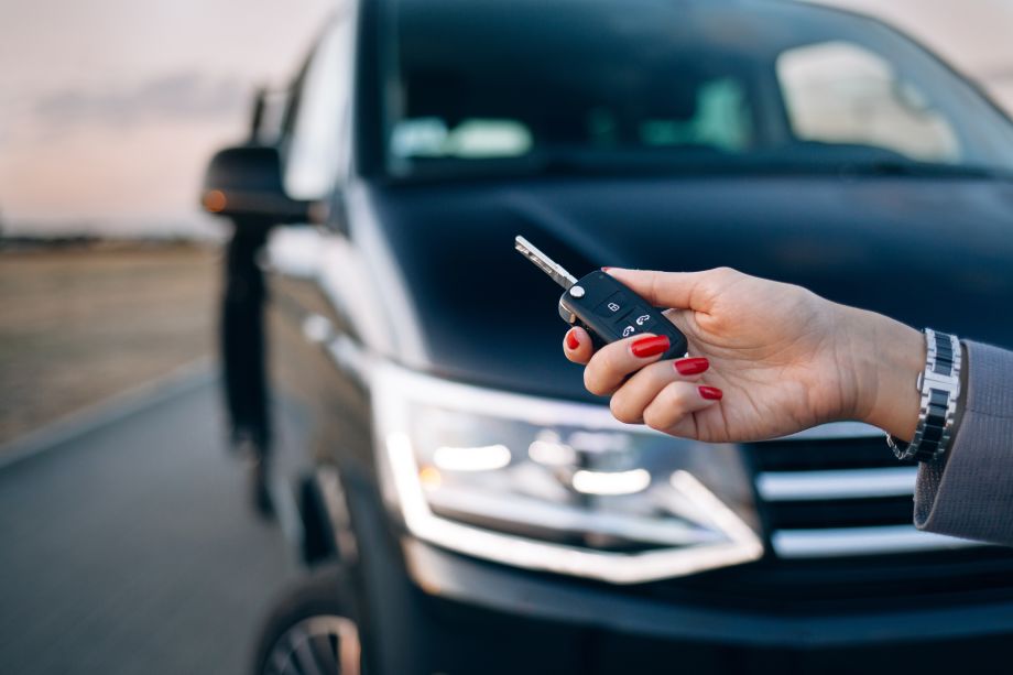 Woman holding key to a black van for hire