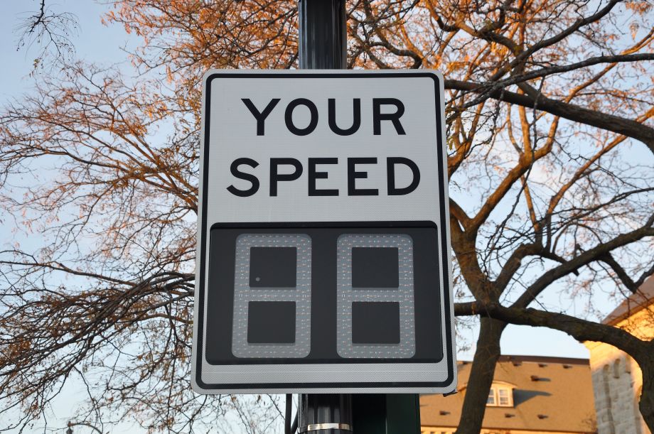 Radar speed sign by a street in autumn