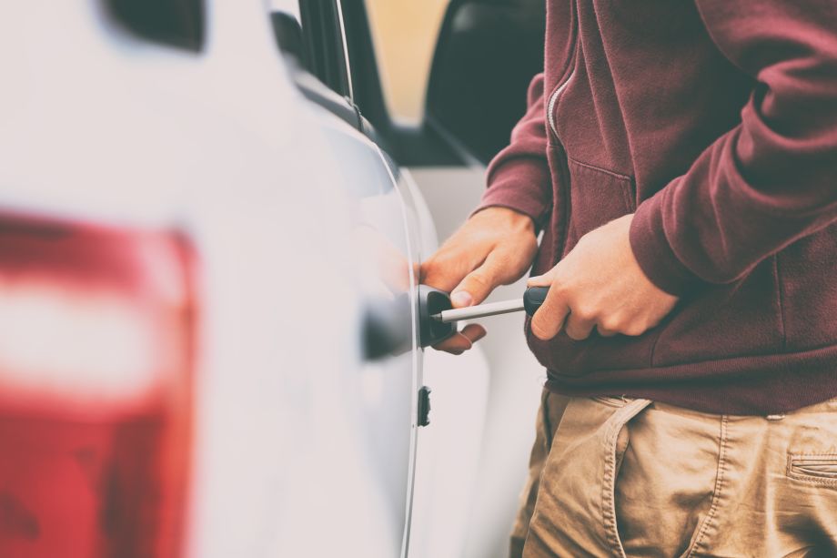 Thief attempting to break into a car