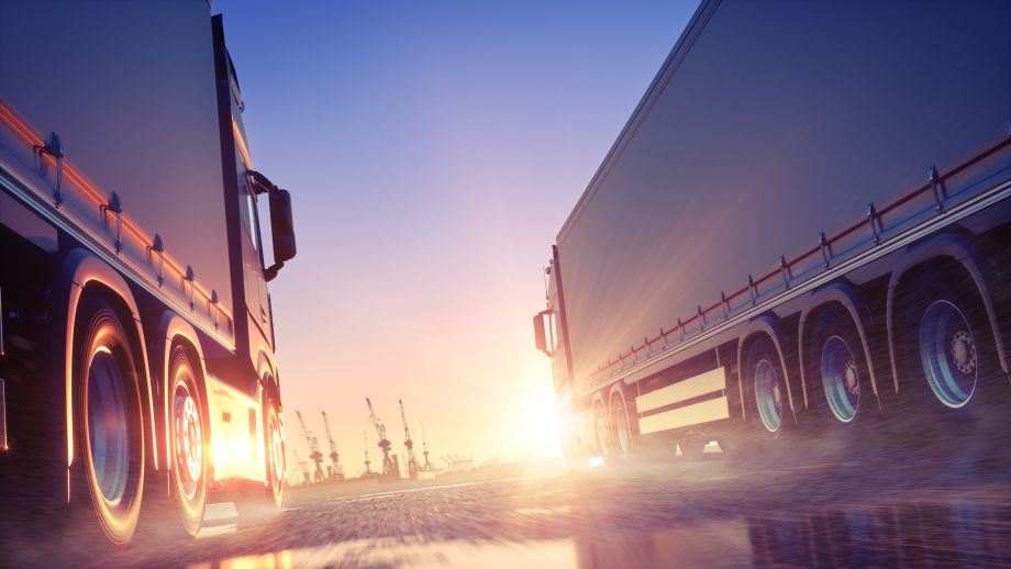 Two trucks driving side by side at sunset