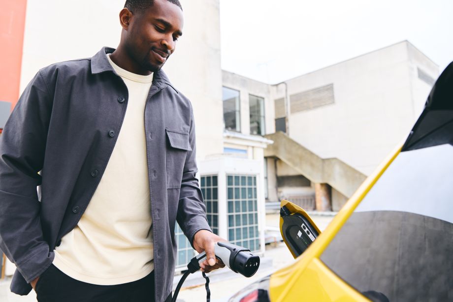 Man using workplace charging point to charge work vehicle