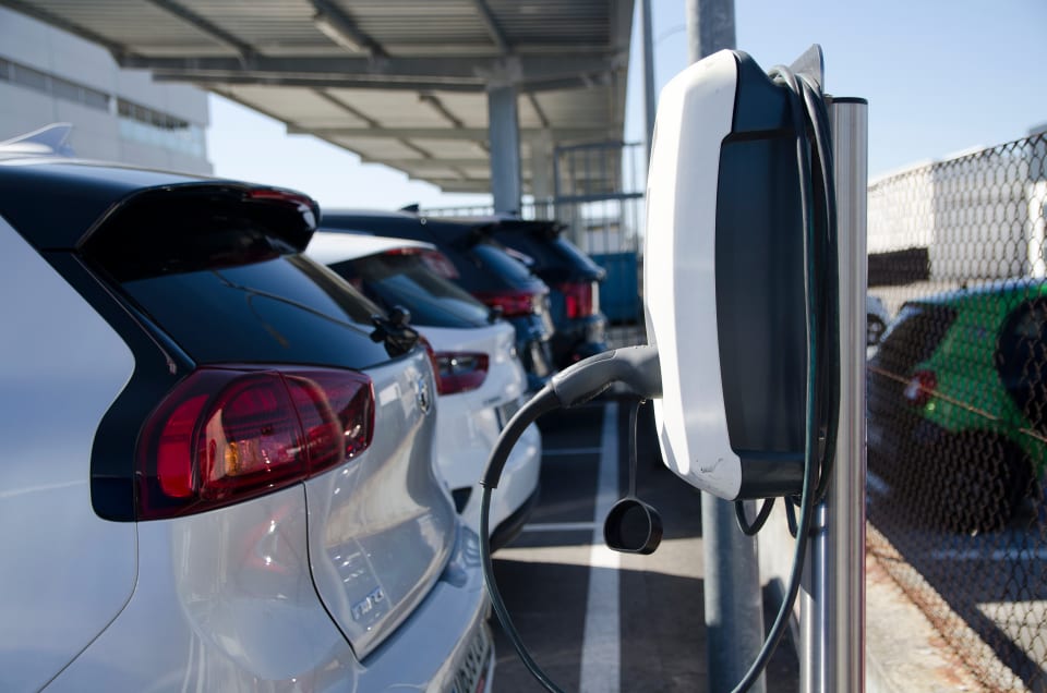 A line of electric vehicles charging at charge points