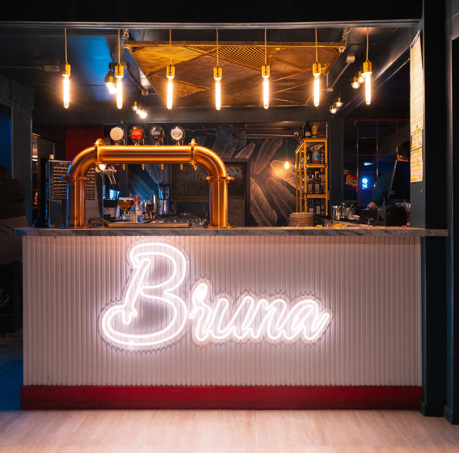 Interior de Bruna Gastrobar: barra con letrero de neón