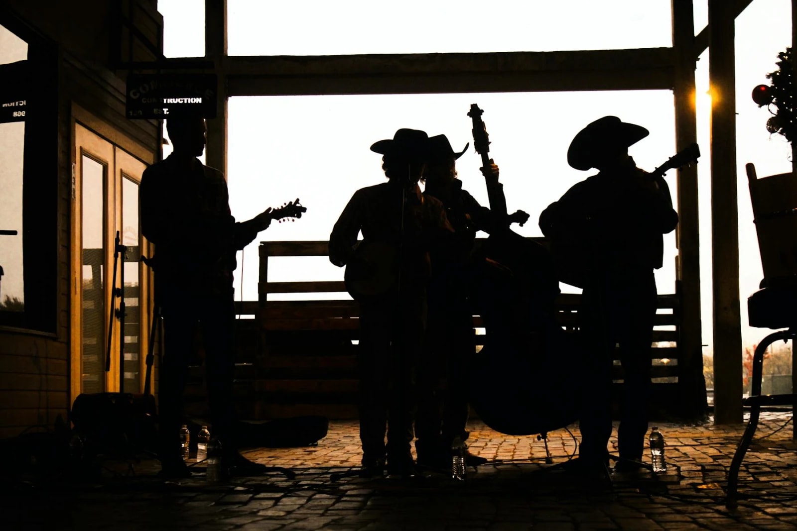 Músicos con guitarras vistos de espaldas en un ambiente cercano