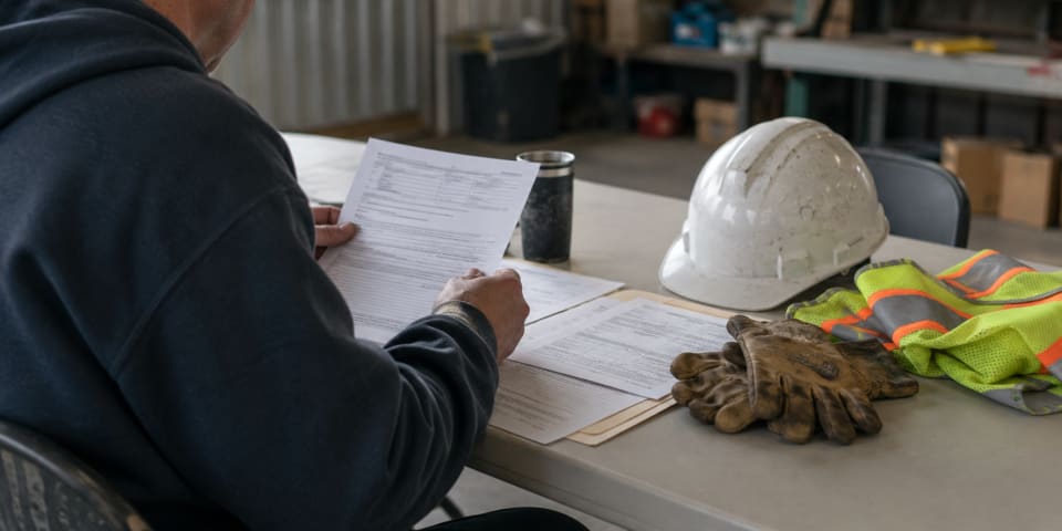 Worker reviewing Idaho workers compensation claim paperwork and benefits forms
