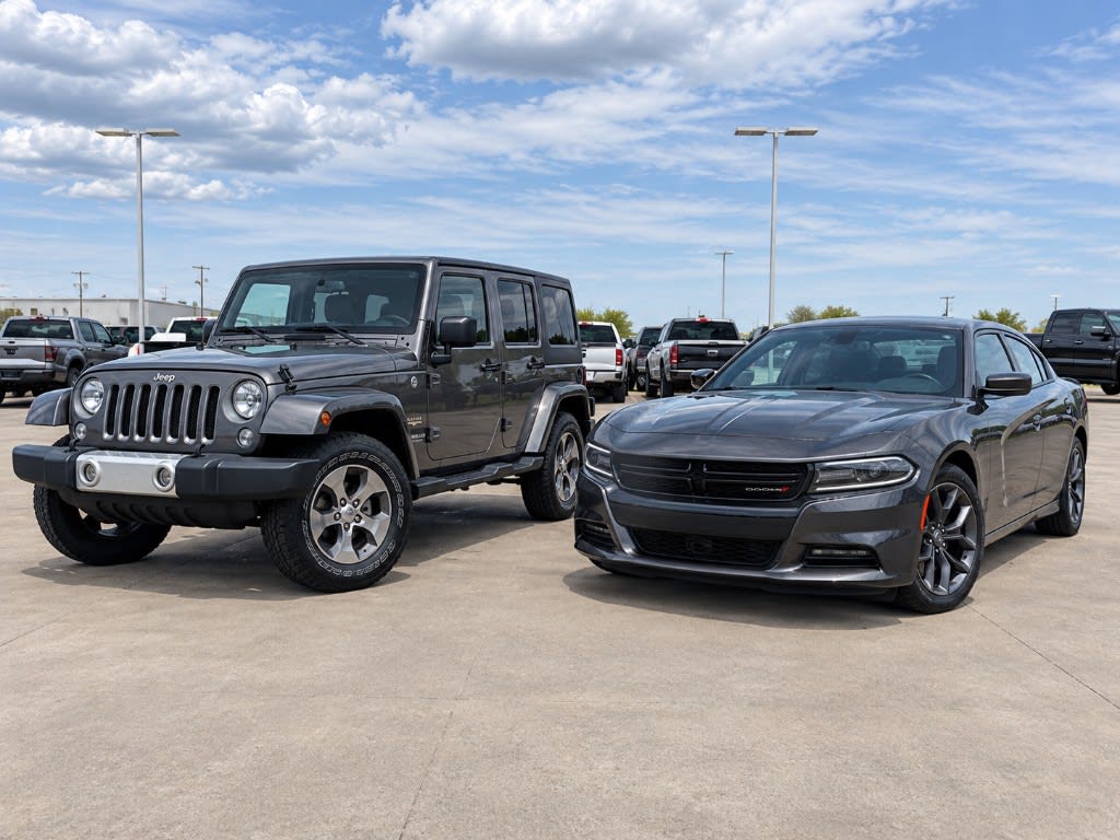 Used Jeep SUV and Dodge sedan parked side by side at Wareing Motors