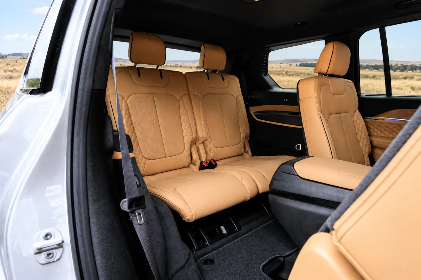 Open rear door of a Grand Cherokee L showing the second-row seats and part of the third-row seat