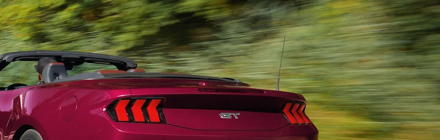 Rear of a red Ford Mustang GT convertible with the GT badge between the taillights
