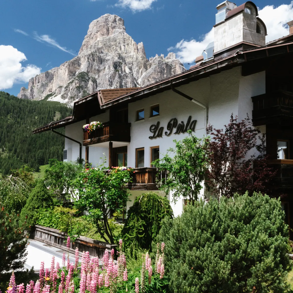 Hotel La Perla in Corvara, Alta Badia, in summer with the Sassongher peak behind it