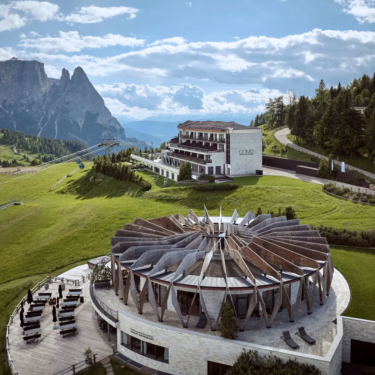 Aerial view of COMO Alpina Dolomites on the Alpe di Siusi with the Sciliar massif behind