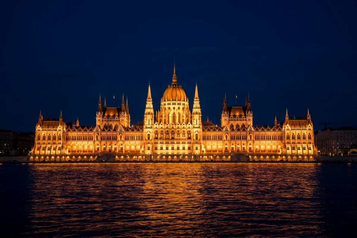 The Hungarian Parliament Building lit up at night across the Danube.
