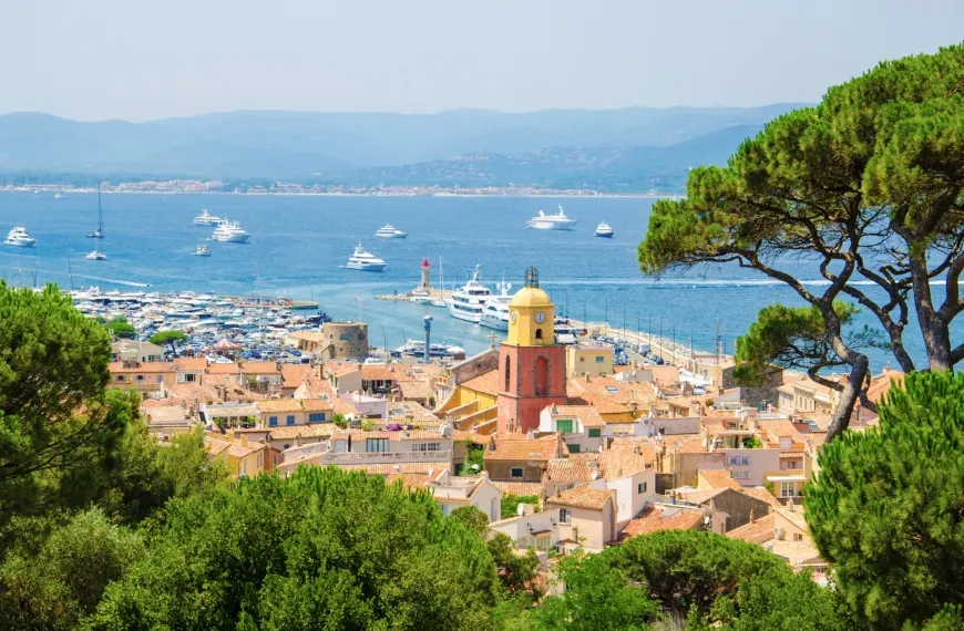 Saint-Tropez village rooftops and church tower with superyachts in the Gulf of Saint-Tropez