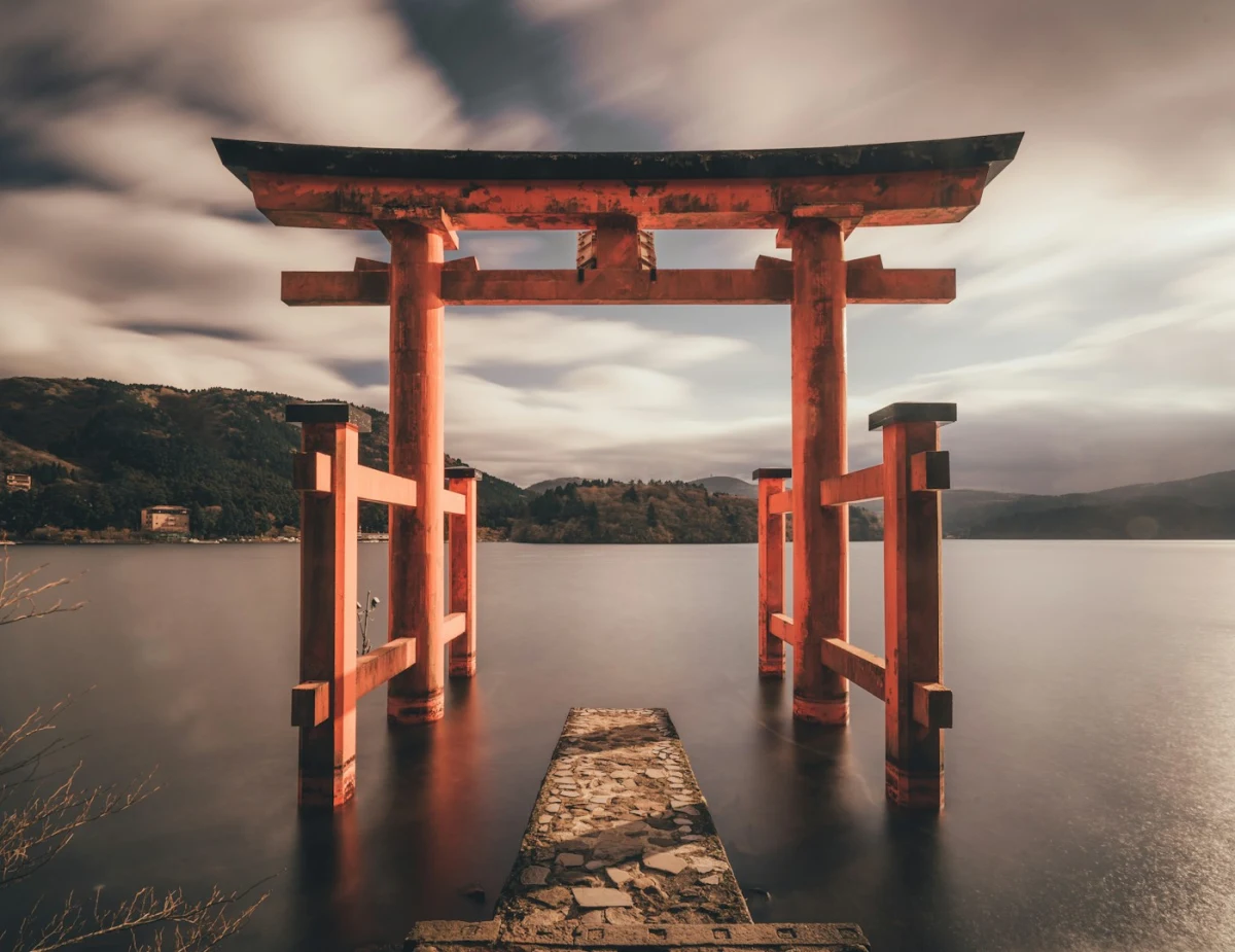 red torii gate standing in lake Japan traditional shrine surrounded by mountains