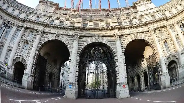 Admiralty Arch London facade with three arches iron gates and Union Jack flags