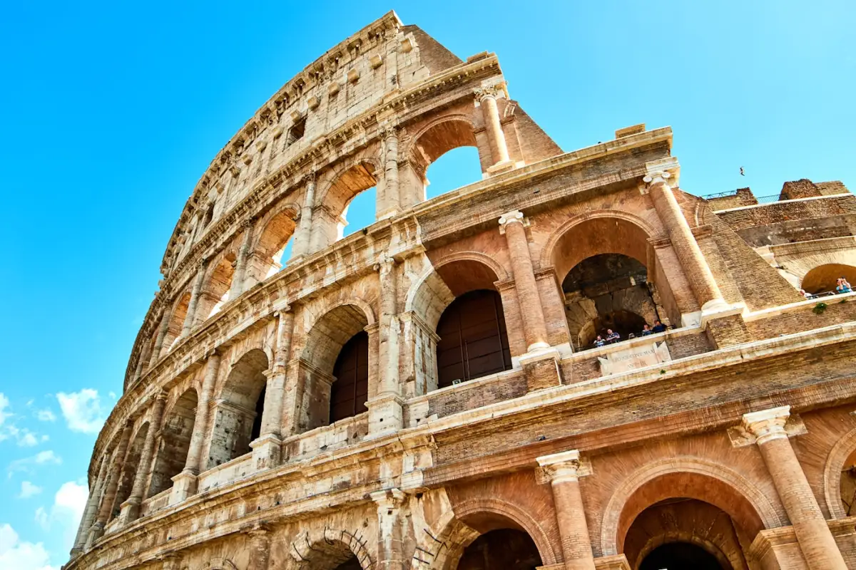 Rome Colosseum daytime stone arches Roman Forum architecture blue sky