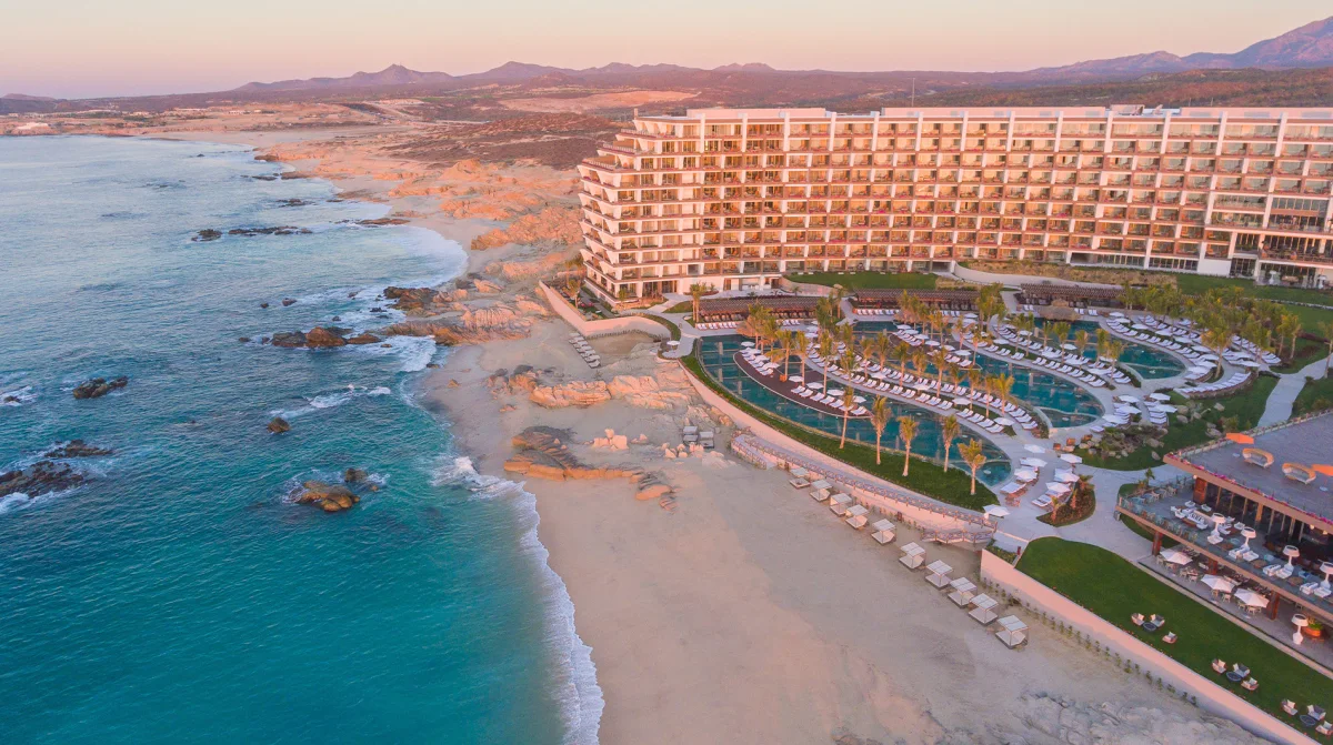 Grand Velas Los Cabos panoramic aerial exterior three-tier infinity pool Sea of Cortez at sunset