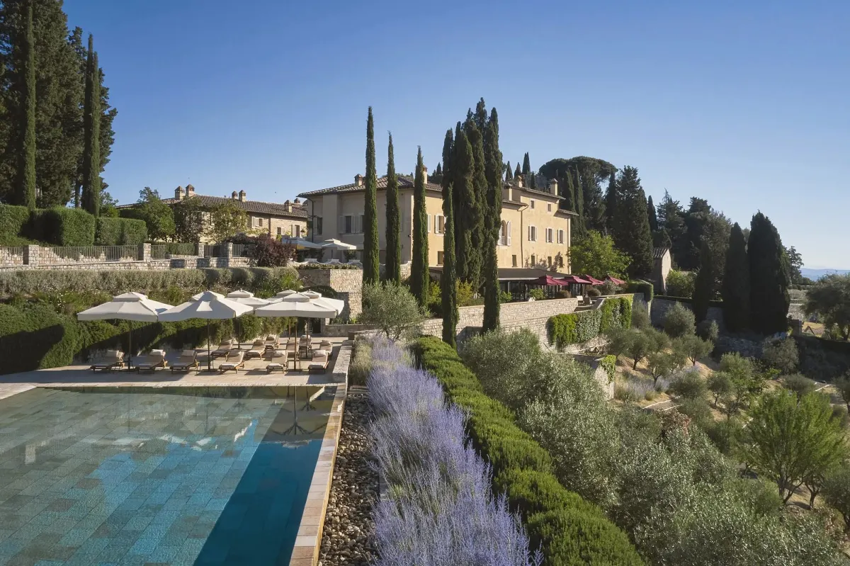 Rosewood Castiglion del Bosco pool with the historic borgo and cypress trees in background