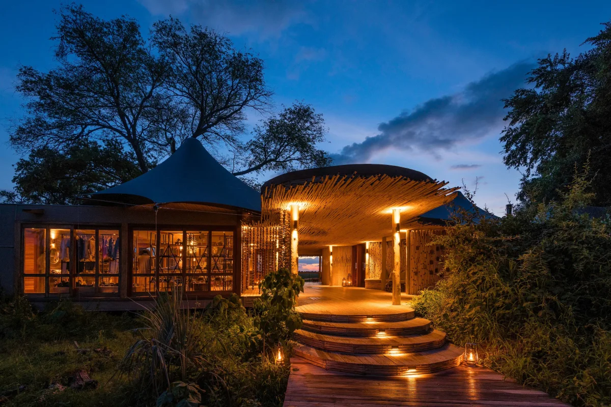 Wilderness Mombo luxury safari camp lit up at dusk in the Okavango Delta