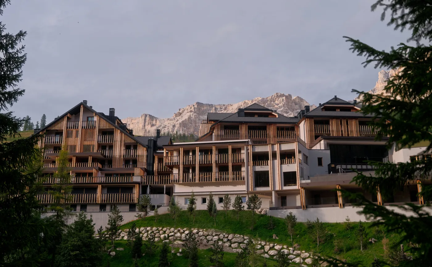 Aman Rosa Alpina in San Cassiano, Alta Badia, with the Dolomites behind it in summer