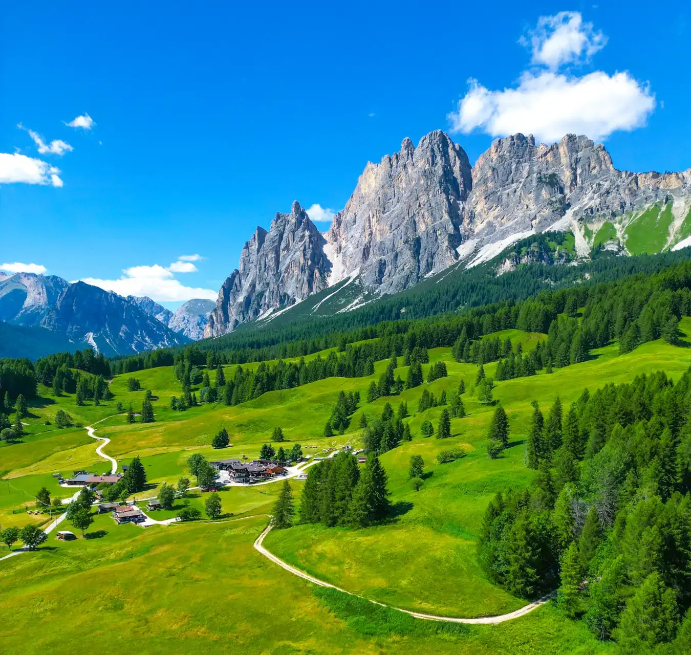 Cortina d'Ampezzo Dolomites valley aerial with distinctive limestone spires and alpine meadows Italy