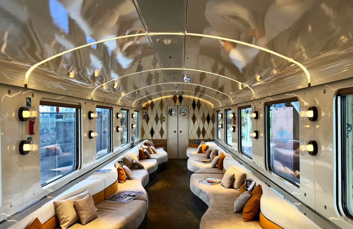 A sleek train lounge with curved sofas and warm lighting