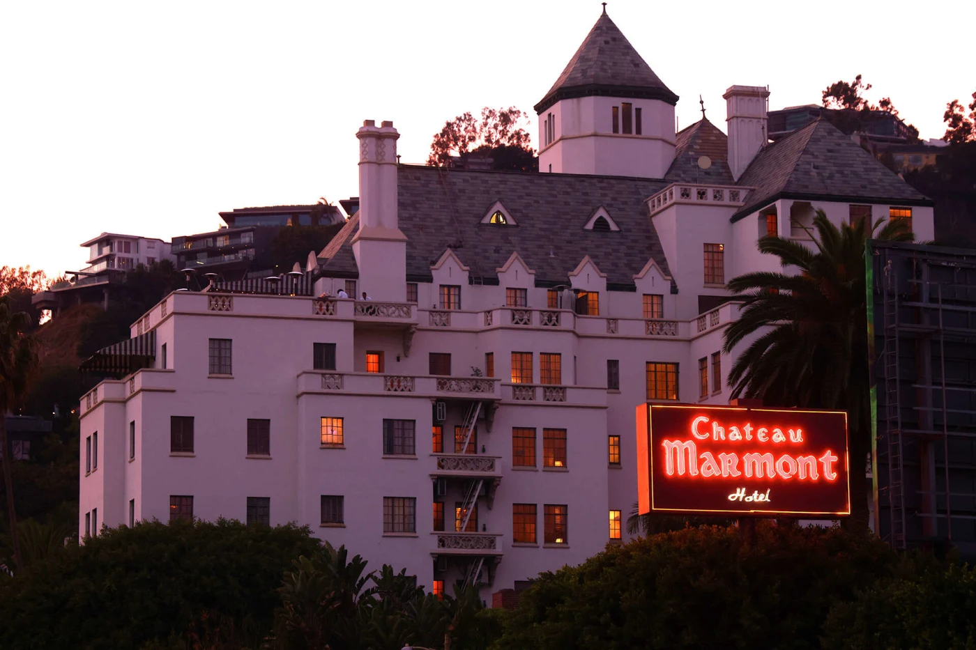 Chateau Marmont exterior at dusk with glowing neon sign on the Sunset Strip