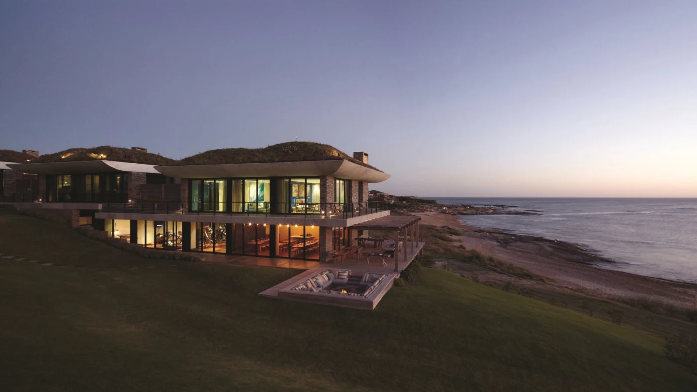 Playa Vik José Ignacio grass-roofed casas at dusk above the Atlantic, the best hotel in José Ignacio Uruguay