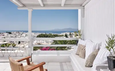 Mykonos vs Ibiza: a Mykonos hotel terrace overlooking the white town and Aegean Sea