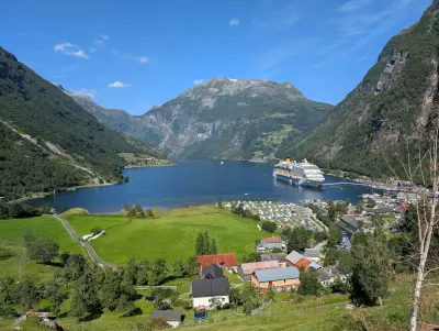 Geirangerfjord and the village of Geiranger in summer, Norway, surrounded by green mountains