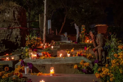 Candlelit graves covered in orange marigolds during the Day of the Dead vigil at the Xoxocotlán cemetery in Oaxaca
