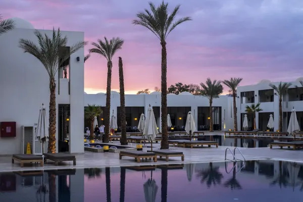 Resort pool at sunset — Aman vs Four Seasons luxury hotel comparison
