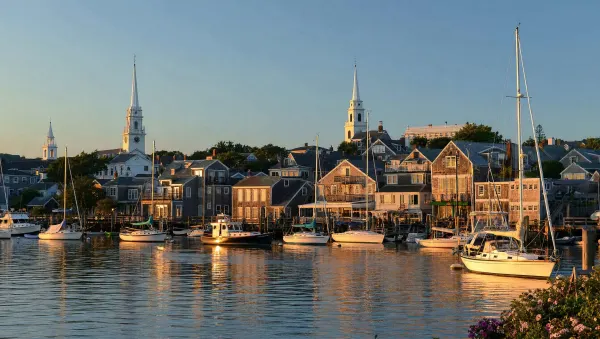 Nantucket harbor at golden hour, with the grey-shingled historic town along the waterfront
