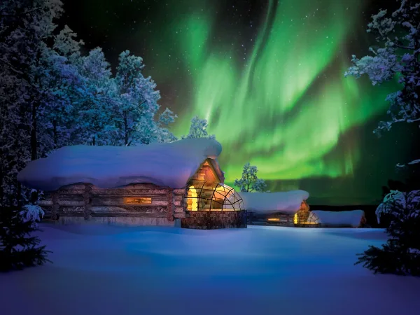 Green northern lights over a glass igloo at Kakslauttanen Arctic Resort in Finnish Lapland