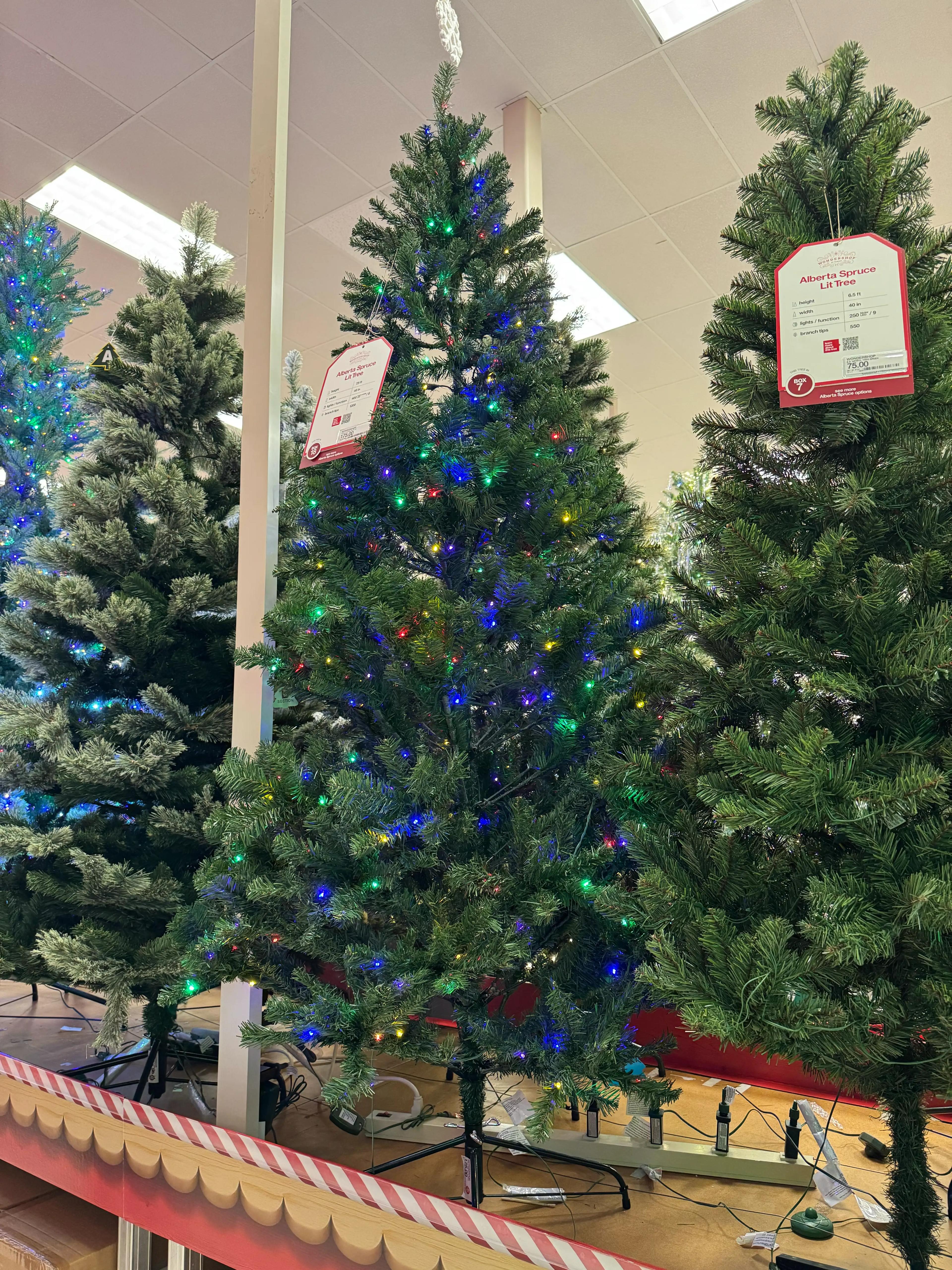 Budget spruce tree with sparse PVC branches, visible gaps, multicolor mini bulbs concentrated at tips, underwhelming fullness despite database rating