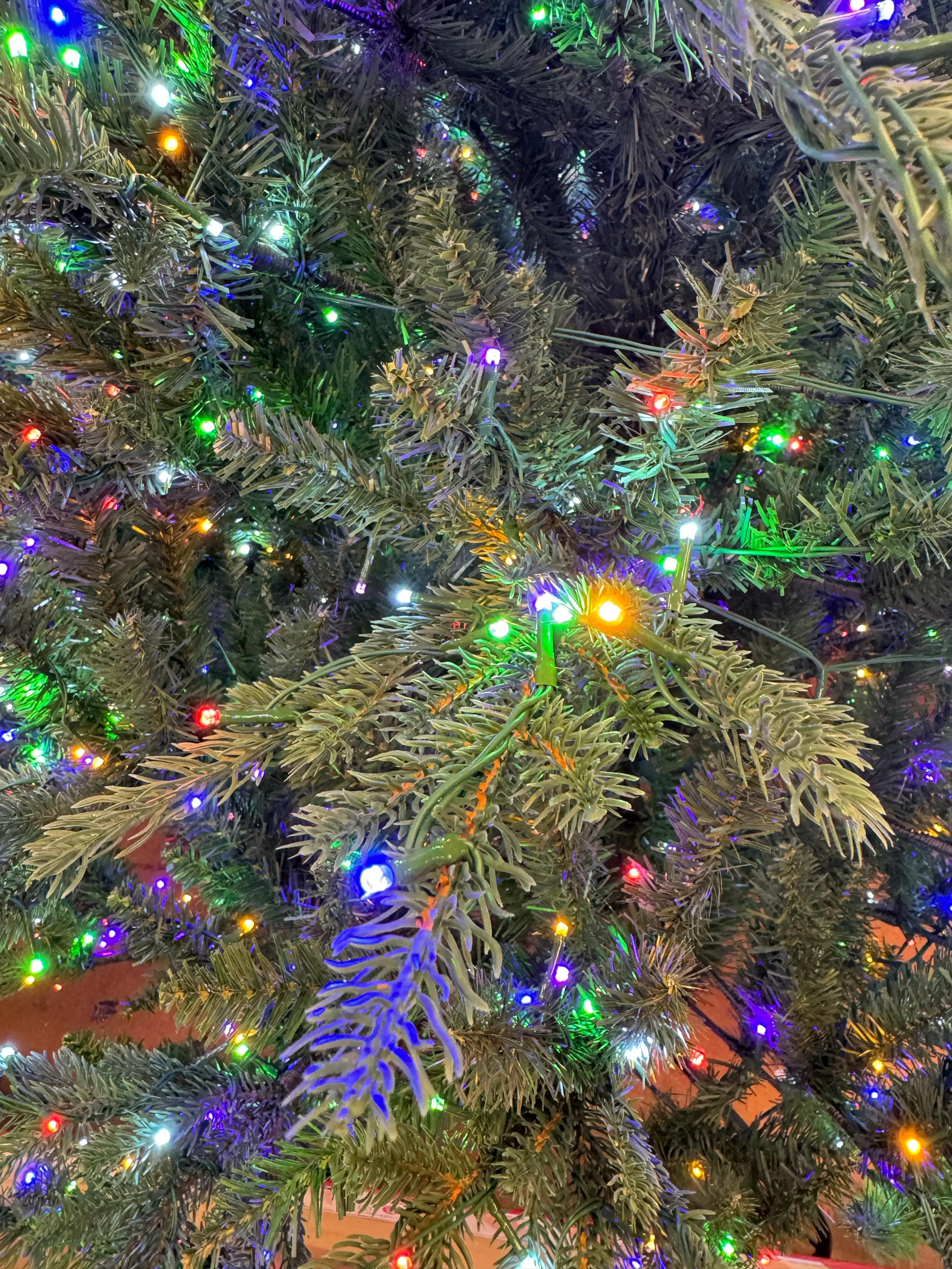 Mixed PVC/molded PE needles with multicolor LED lights, dense coverage, visible metallic green wire between branches