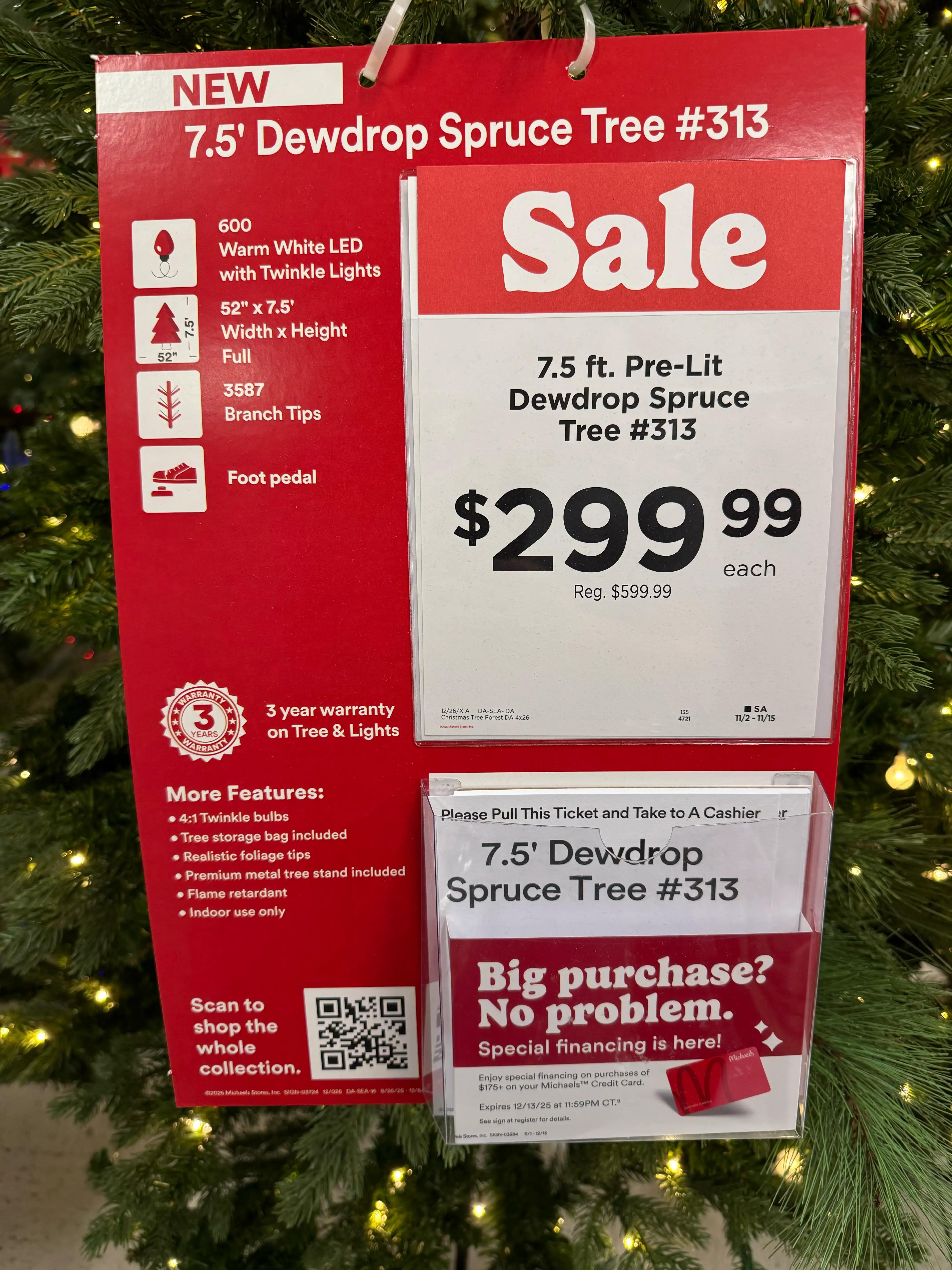 Product sign showing sale price $299.99 for 7.5' pre-lit tree with specs: 600 warm white LEDs, 3587 branch tips