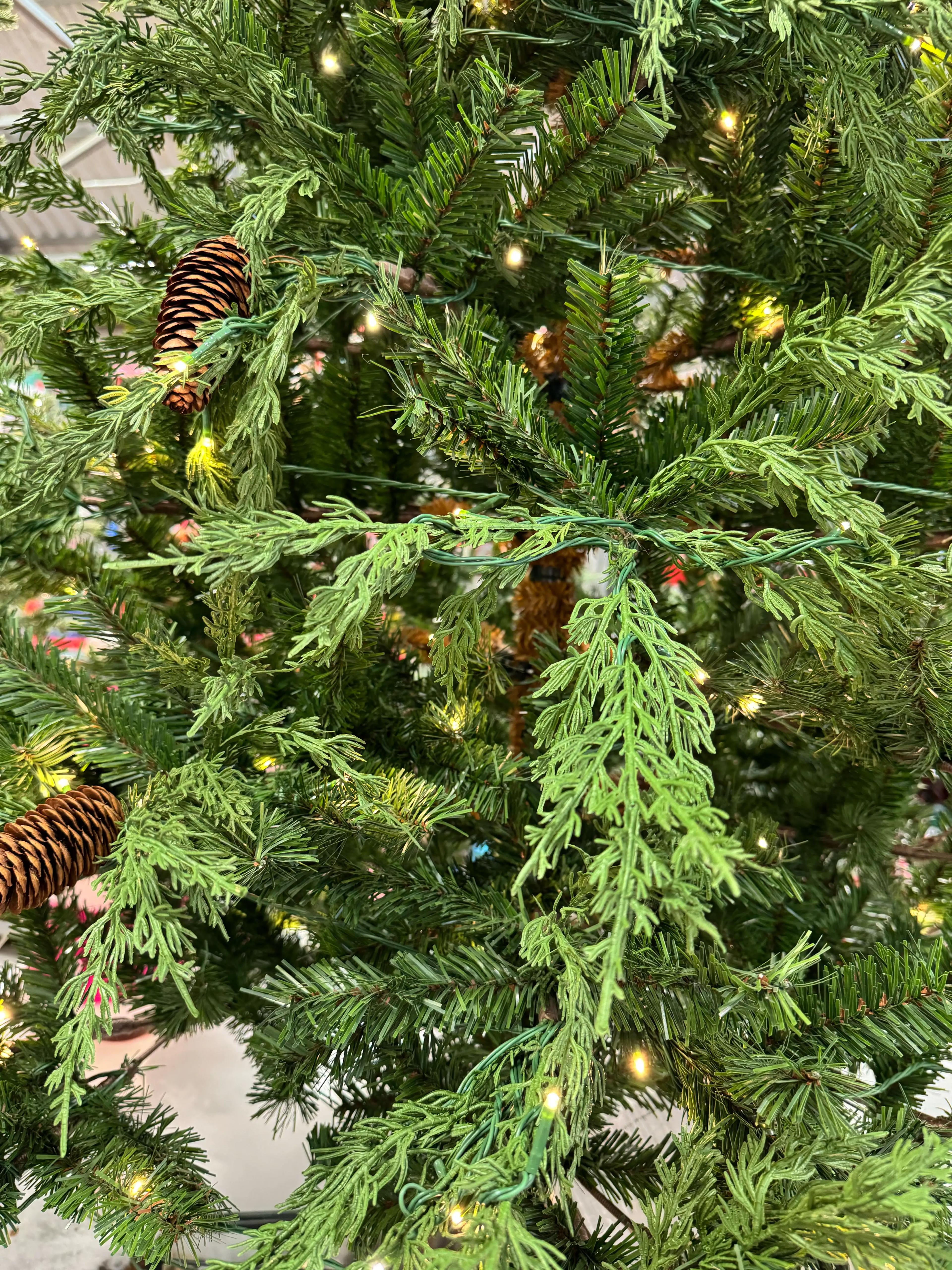 Mixed PVC/molded PE cypress needles with pine cones, warm white micro LEDs, moderate density with visible gaps