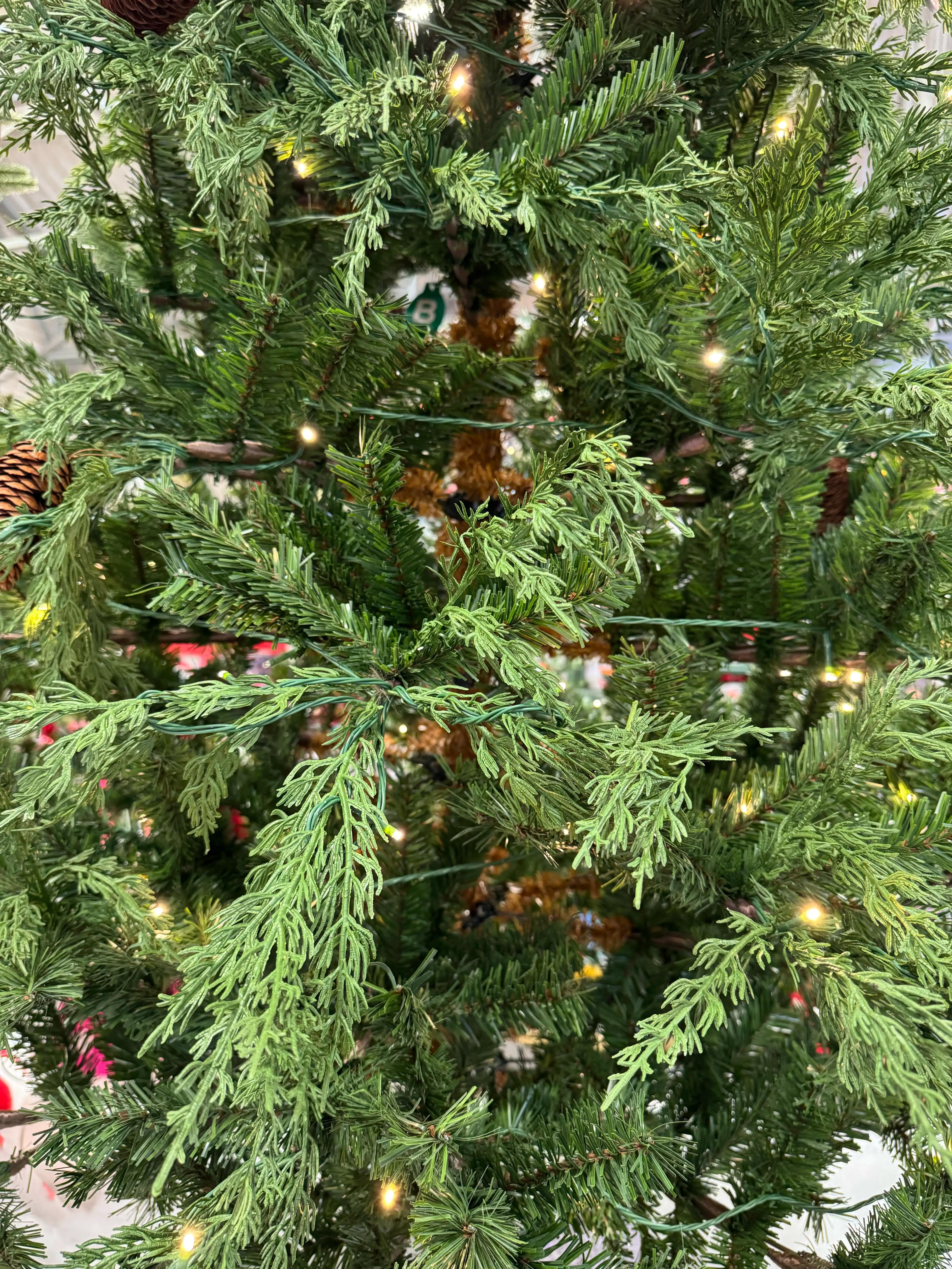 Mixed PVC and molded PE cypress-style needles with warm white lights, moderate branching, some visible gaps