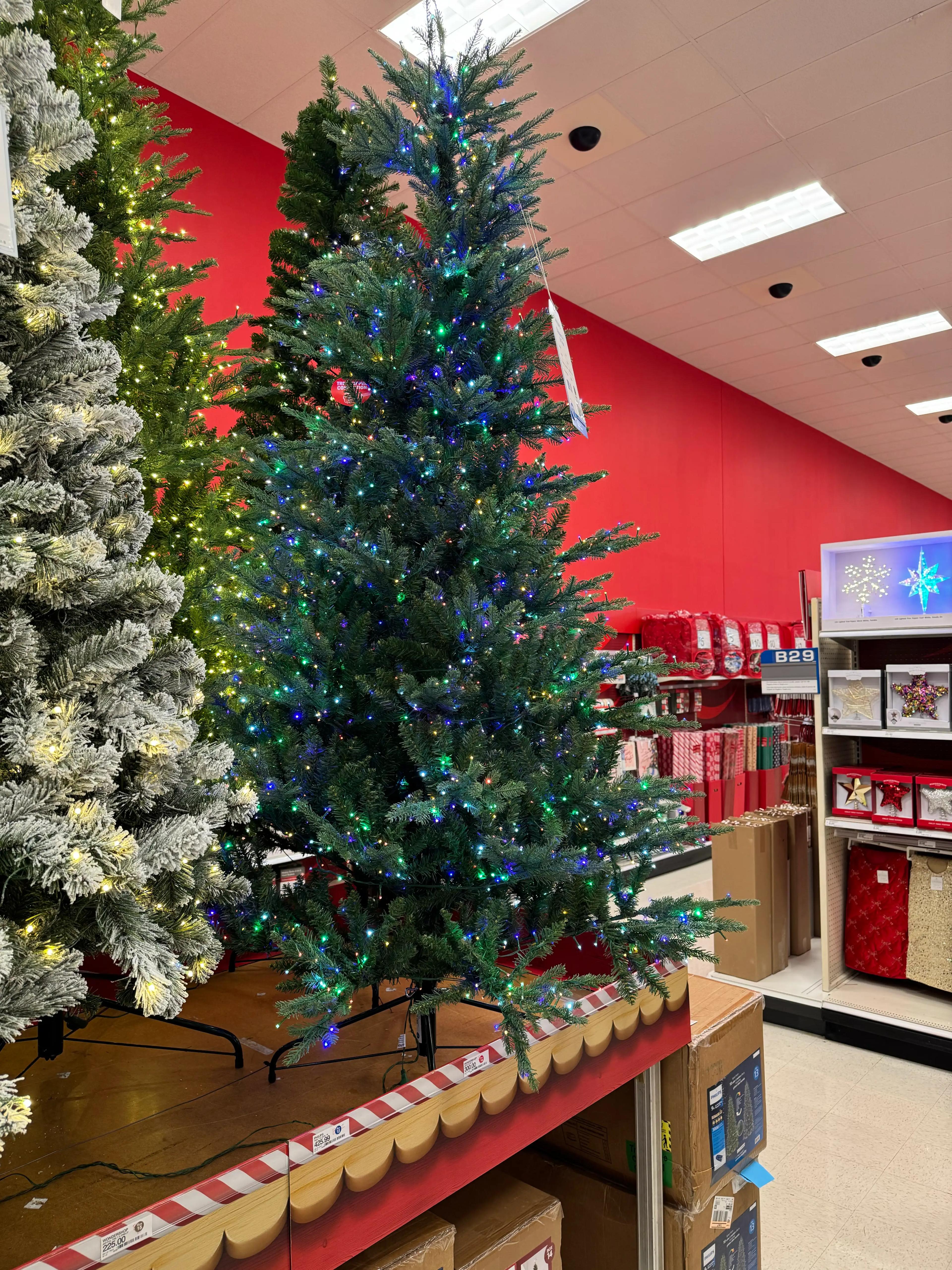 Full spruce-style tree with moderate PVC branching, multicolor LED lights densely distributed, minimal gaps