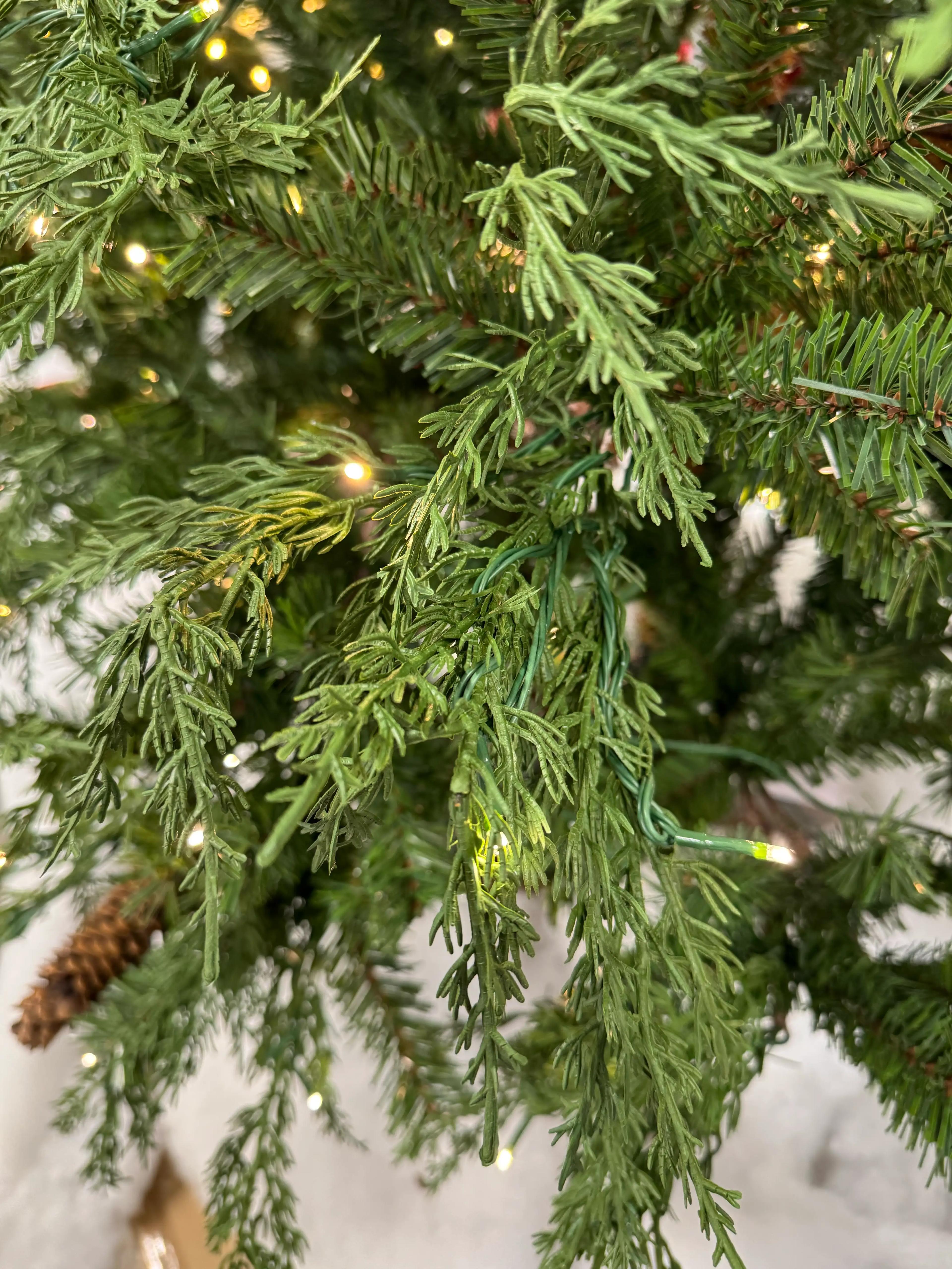 Mixed PVC and molded PE cypress-style needles with warm micro LEDs, moderate density showing some branch gaps