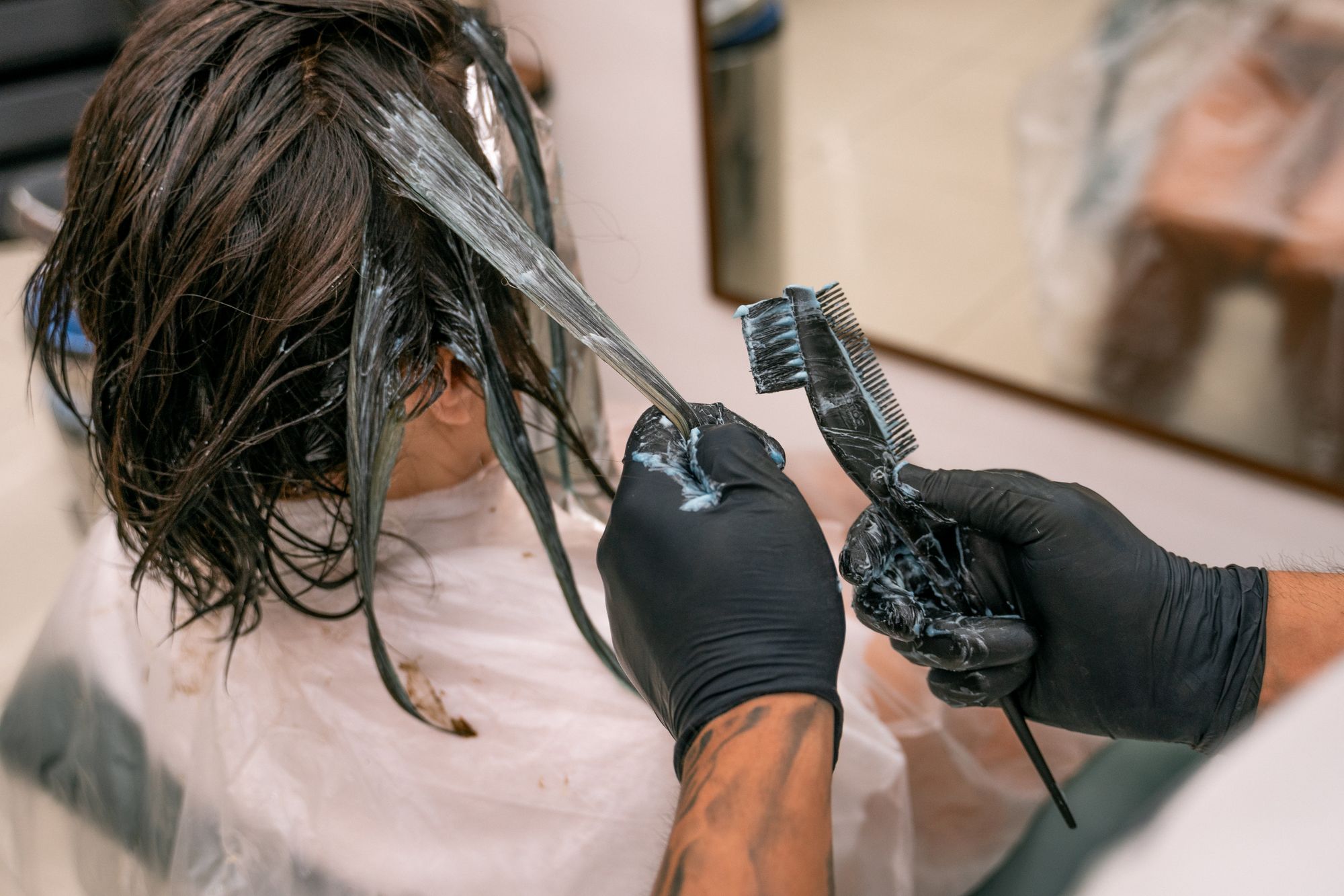 Colorist painting a lightened section through a client's hair in the salon