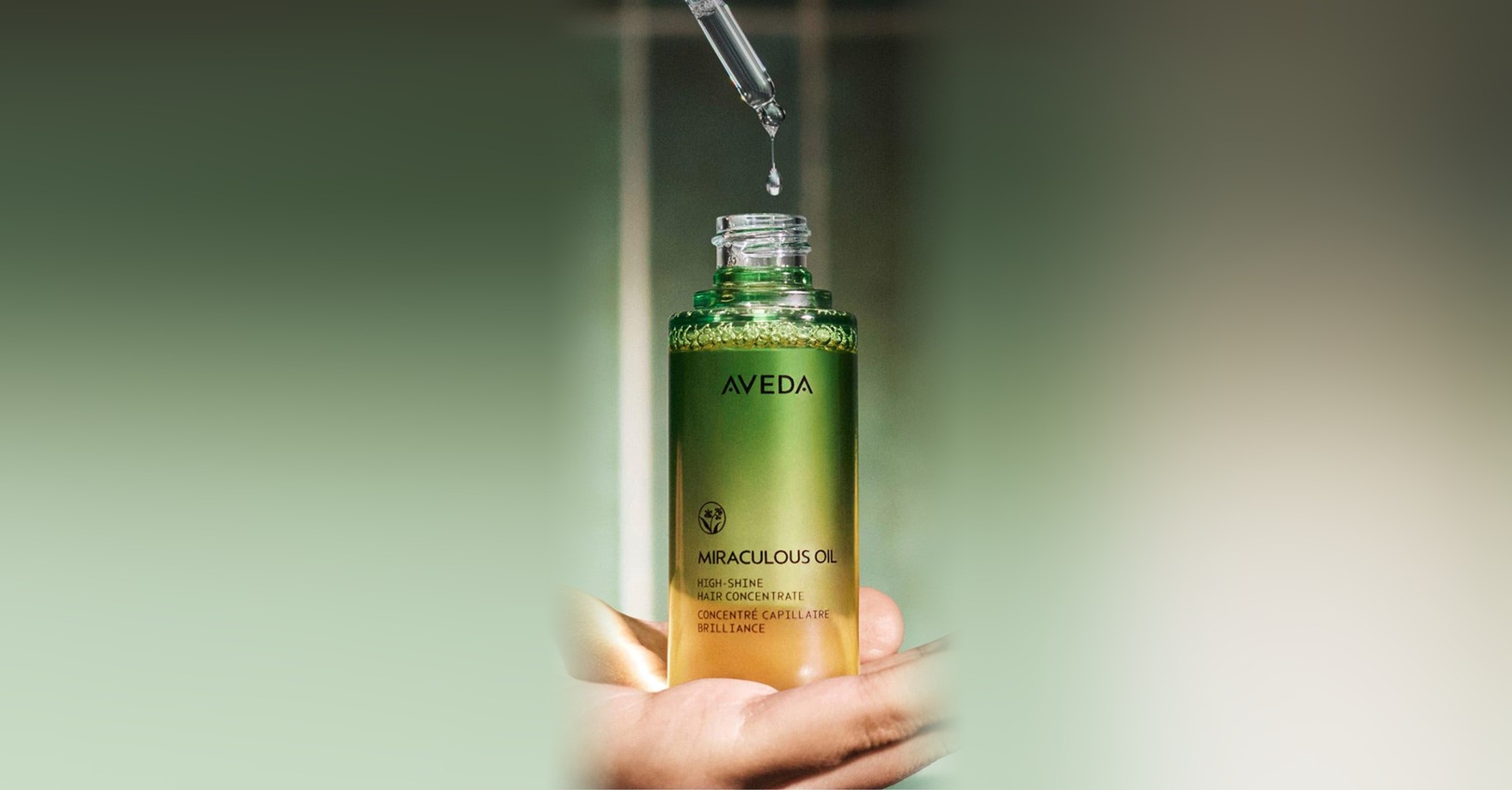 Aveda Miraculous Oil High Shine Hair Concentrate bottle with a drop falling from its dropper