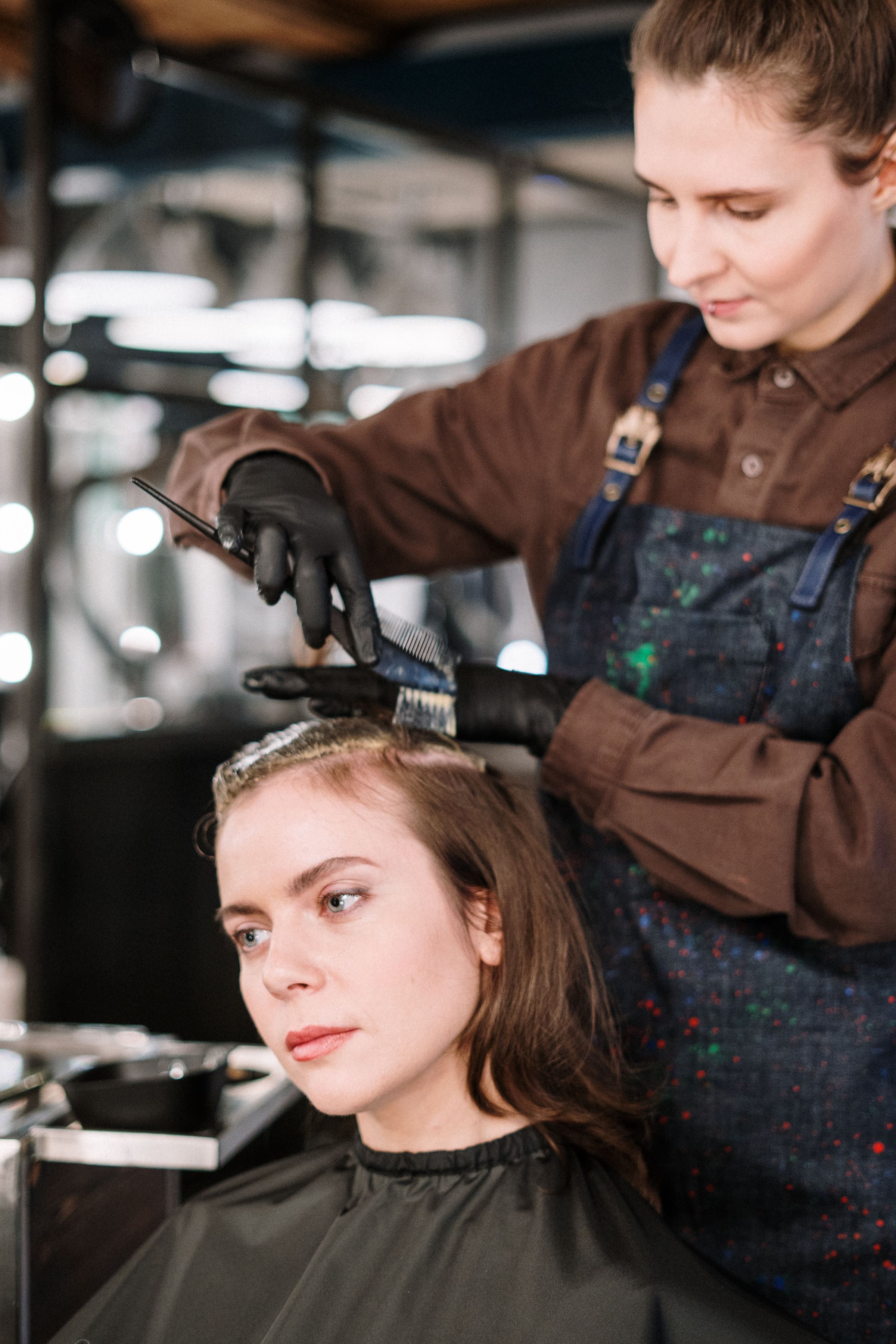 Colorist sectioning and brushing color onto a client's roots