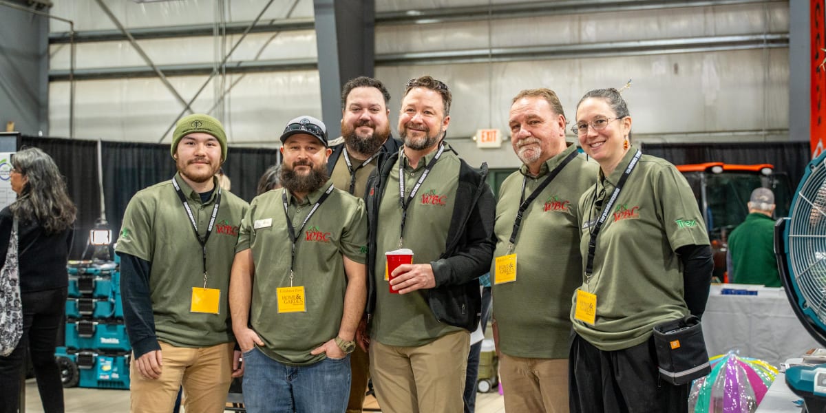 Six Western Building Center team members posing together at what appears to be the 2025 Home and Garden Show, all wearing mat